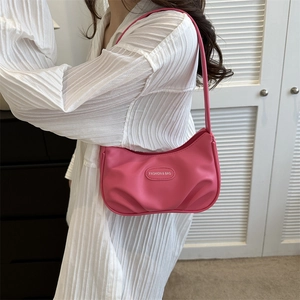 Sac sous le bras plissé rose fuchsia en cuir PU brillant porté par un mannequin