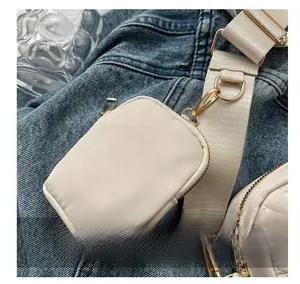 Dettaglio della mini borsa beige trapuntata con cerniera dorata e moschettone