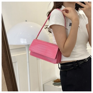 Borsa sottobraccio rosa acceso alla moda con texture a pieghe verticali su un modello