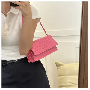 Dettaglio ravvicinato della borsa a tracolla plissettata rosa con patta magnetica e tracolla