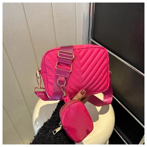Dettaglio della borsa a tracolla trapuntata rosa acceso con mini astuccio sulla spalla