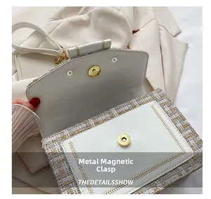 Nahaufnahme der Tweed-Tasche mit weißem Leder und hochwertigem goldfarbenem Magnetverschluss