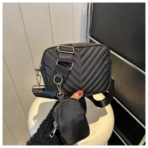 Dettaglio della borsa a tracolla trapuntata nera in nylon con mini portamonete rimovibile e oro