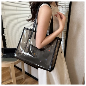 Detailed view of clear PVC tote bag with colorful rhinestones and black inner pouch