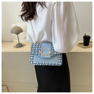 Blaue Tweed-Umhängetasche mit Goldschnalle am Model in gemütlicher Inneneinrichtung