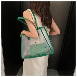 Green trim transparent tote bag with colorful rhinestones shown on model side view