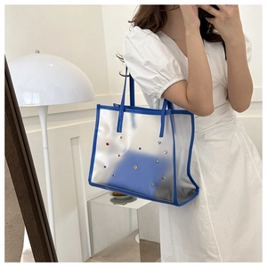 Detail of transparent blue tote bag with colorful rhinestones on a female model