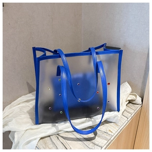 Detail of blue leather trim and colorful studs on a frosted transparent tote bag