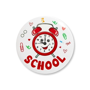 Detail of school themed badge with red alarm clock and school text on white surface