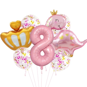 Détail de ballons rose chiffre 8, couronne et dinosaure pour décor de fête d'anniversaire