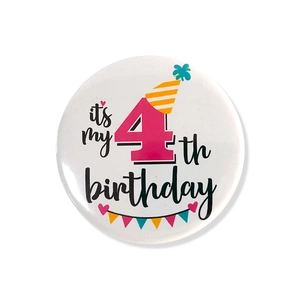 Detailed close-up of 4th birthday tinplate badge with colorful party hat and heart design