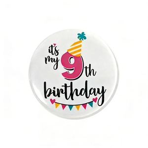Detail of 9th birthday tinplate badge with colorful hat and banner party decorations