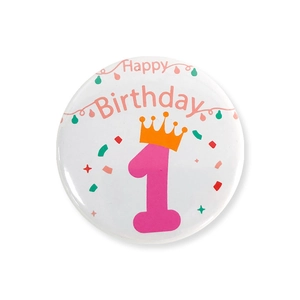 Détail d'un badge rond en fer-blanc pour 1er anniversaire avec numéro rose et couronne