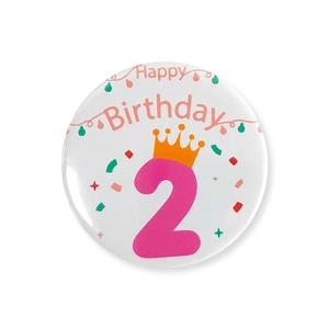 Vue détaillée du badge Happy Birthday blanc et rose avec numéro 2 et couronne