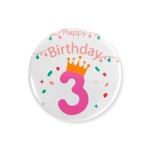 Détail d'un badge d'anniversaire avec numéro 3 rose et texte Happy Birthday décoré
