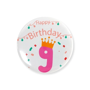 Gros plan du badge d'anniversaire avec chiffre 9 rose et décoration de couronne festive