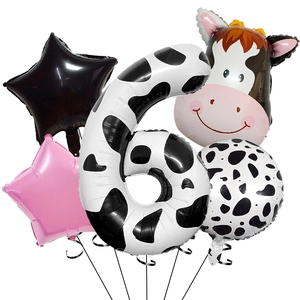 Detail view of a cow themed party set featuring a large number 6 and cow head balloon