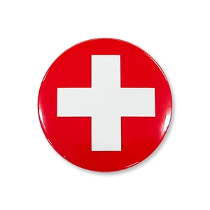 Close-up of a round red nurse badge with a white cross and glossy metal finish