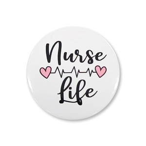 Macro detail of Nurse Life tinplate badge with heartbeat rhythm and pink heart graphics