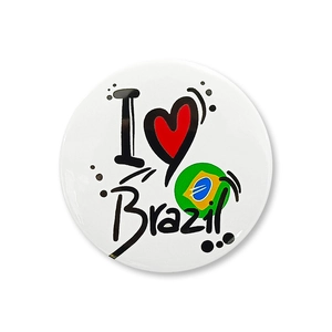 Détail d'un badge rond en fer-blanc avec logo I Heart Brazil et éléments du drapeau