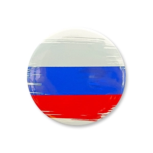 Detail of round tinplate badge featuring artistic Russian flag paint brush texture