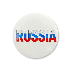 Close-up of a round tinplate badge featuring RUSSIA text in Russian flag colors