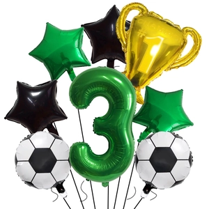 Macro shot of champion trophy and football foil balloons for a 3rd birthday party decor