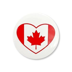 Primo piano di una spilla tonda in latta con bandiera canadese a forma di cuore