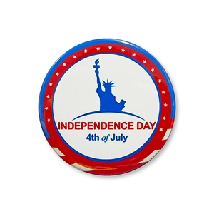Macro detail of July 4th tin badge with Statue of Liberty and Independence Day text