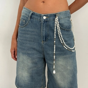 Multilayer faux pearl waist chain with star tassel and gold beads on denim jeans