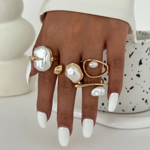 Macro view of gold baroque pearl ring set showing irregular textures and glossy finishes