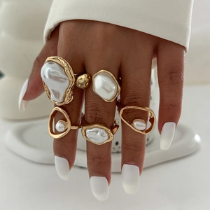 Detailed view of women wearing a 5-piece baroque pearl gold ring set in lava style