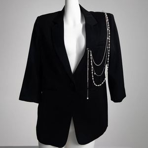 Broche étoile avec perles d'imitation sur un blazer noir avec chaînes multicouches