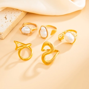 Detail of 5-piece gold ring set featuring irregular baroque pearls and minimalist designs