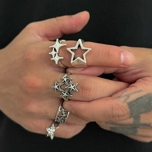 Detail von Vintage-Silberstern-Ringen am Finger mit Sternmustern und Antik-Finish