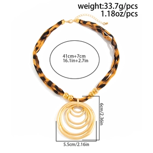 Macro detail of leopard print scarf necklace with golden layered pendant and size specs