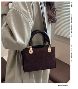 Detail showing deep brown suede texture and clover embossed pattern on square crossbody bag