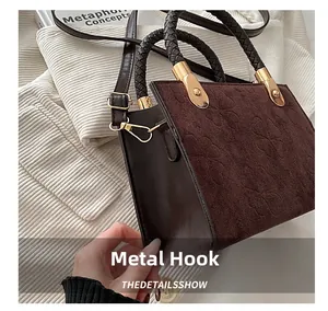 Macro detail of dark brown suede bag with embossed clover patterns and gold hardware