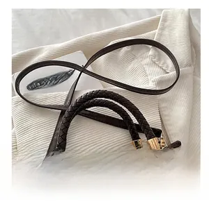 Detail of dark brown suede handbag with woven handle and gold metal hardware
