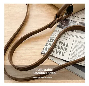 Close-up of adjustable brown leather shoulder strap on a retro patchwork shoulder bag