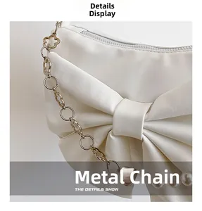 Détail du sac bandoulière blanc en PU avec grand nœud et chaîne dorée perlée