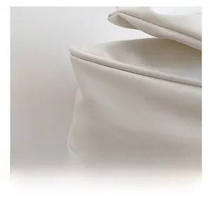 Gros plan d'un sac à main blanc montrant les coutures et la texture du cuir