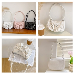 Détail du sac à bandoulière avec un grand nœud décoratif et une chaîne de perles chic