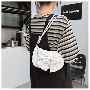 Détail du sac à bandoulière blanc à nœud avec bretelles en perles et chaîne en métal