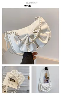 Vue détaillée du sac en cuir blanc avec nœud décoratif et détails de chaîne en perles