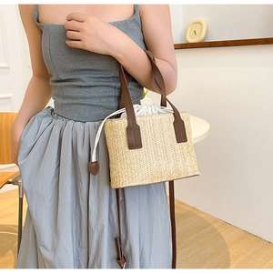 Détail du sac en paille avec lanières en cuir marron et doublure à cordon sur un mannequin