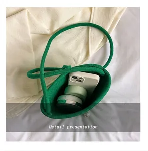 Vue de dessus d'un mini sac tissé vert montrant l'espace pour téléphone et maquillage