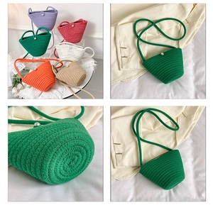 Dettaglio borsa a secchiello intrecciata colorata con bottone a perla e tracolla lunga