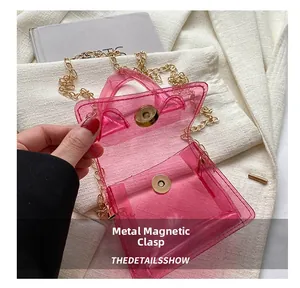 Détail du fermoir magnétique en métal sur le mini sac rose en PVC transparent