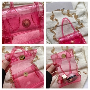 Vue détaillée du mini sac en PVC rose transparent montrant la chaîne dorée et la capacité